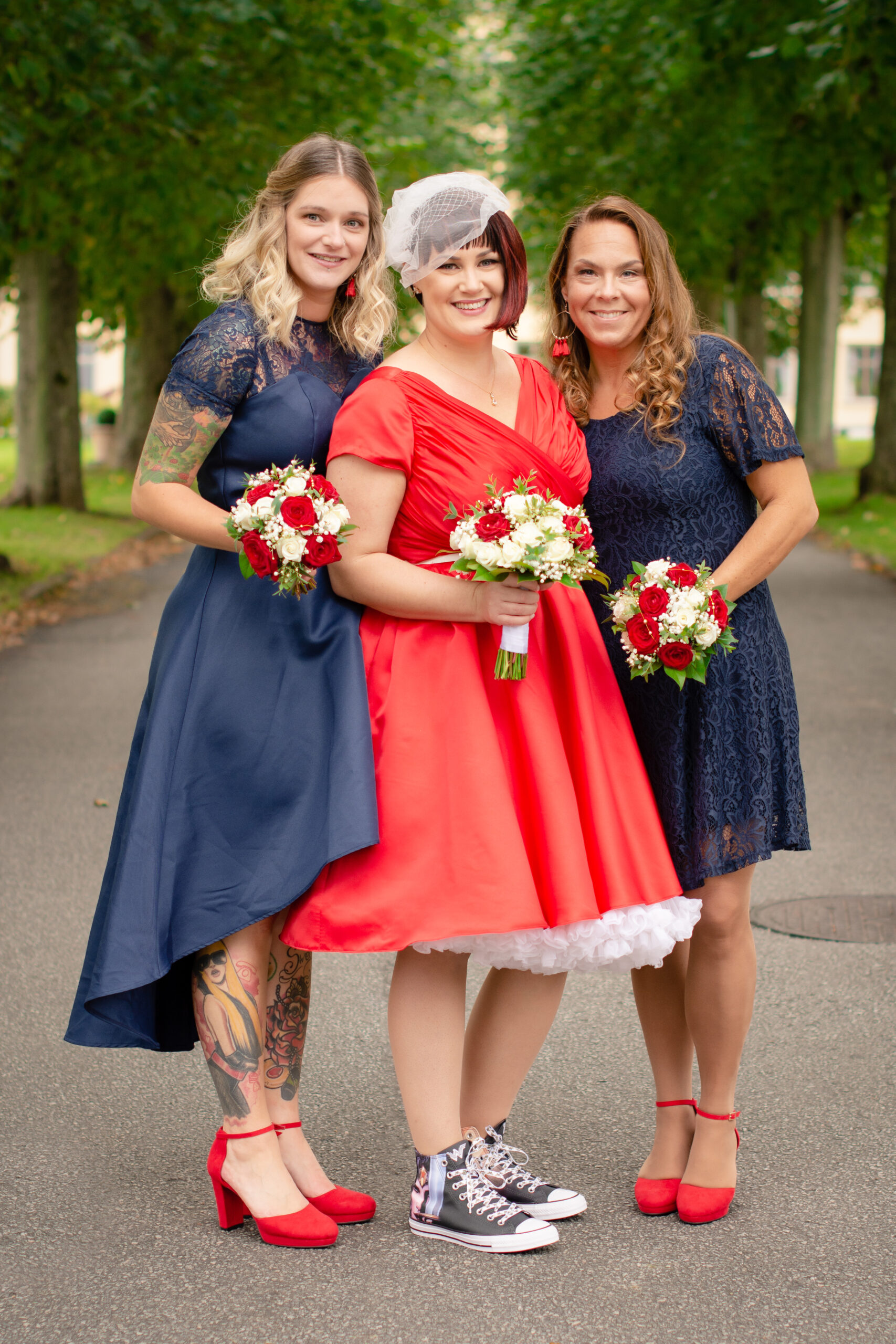 Brud i röd klänning med sina tärnor i blåa klänningar. Foto Martina Ardbäck