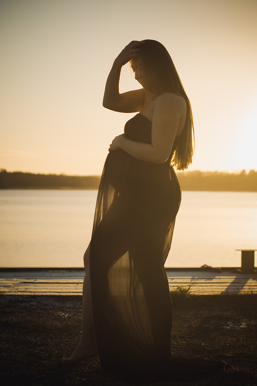 Siluett av gravid i solnedgång, Golden hour vid Mälaren, Strängnäs, Södermanland. Svart skir gravidklänning. Foto Martina Ardbäck