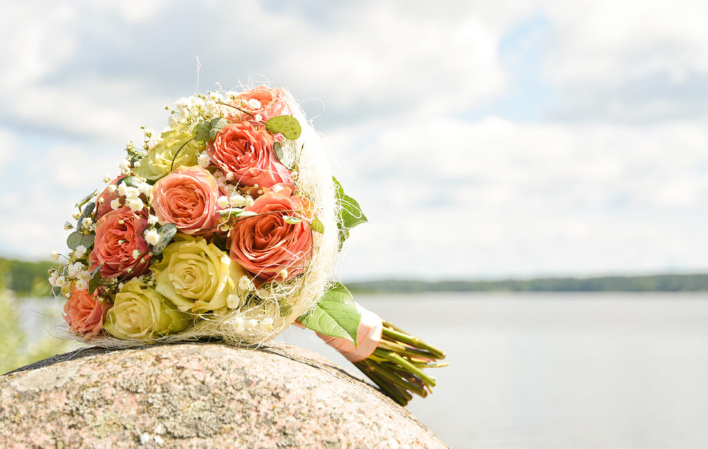 Brudbuketten ligger på en sten med Mälaren i bakgrunden., Strängnäs, Södermanland. Foto Martina Ardbäck