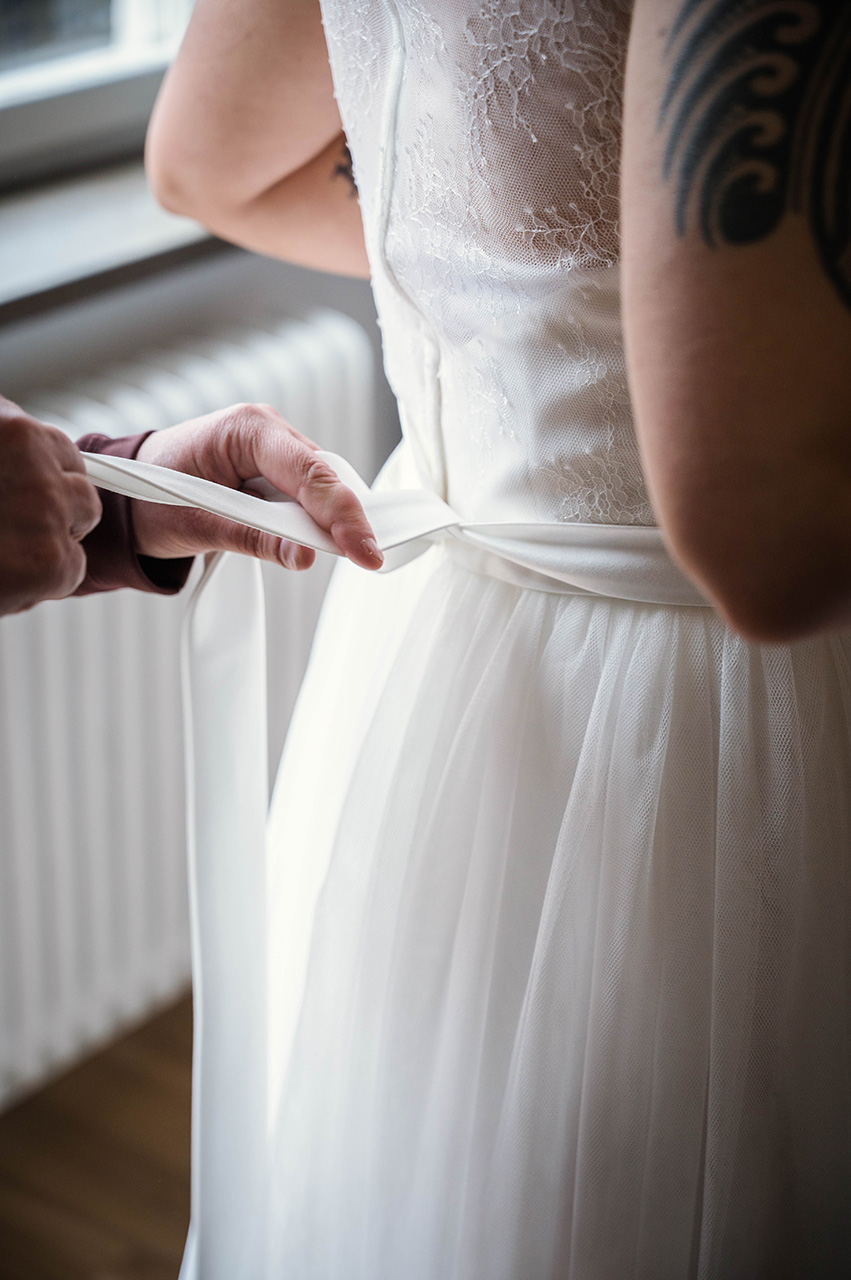 Bröllopsförberedelser, bruden får hjälp med bröllopsklänningen att knyta bandet i ryggen av sin mamma, innan vigseln i Västerås. Foto Martina Ardbäck