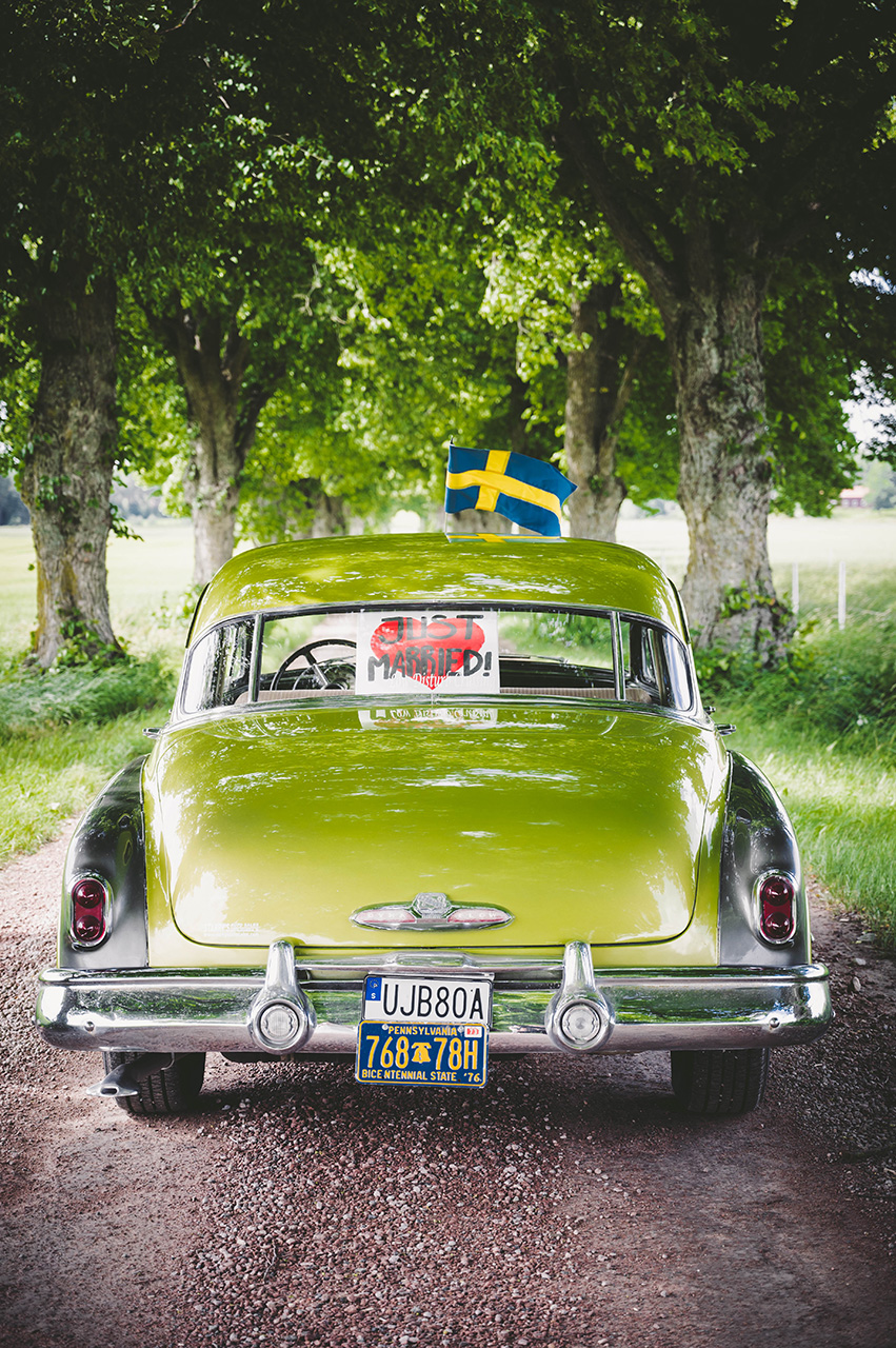 Nygifta, grön bröllopsbil i en allé i Västerås. Foto Martina Ardbäck
